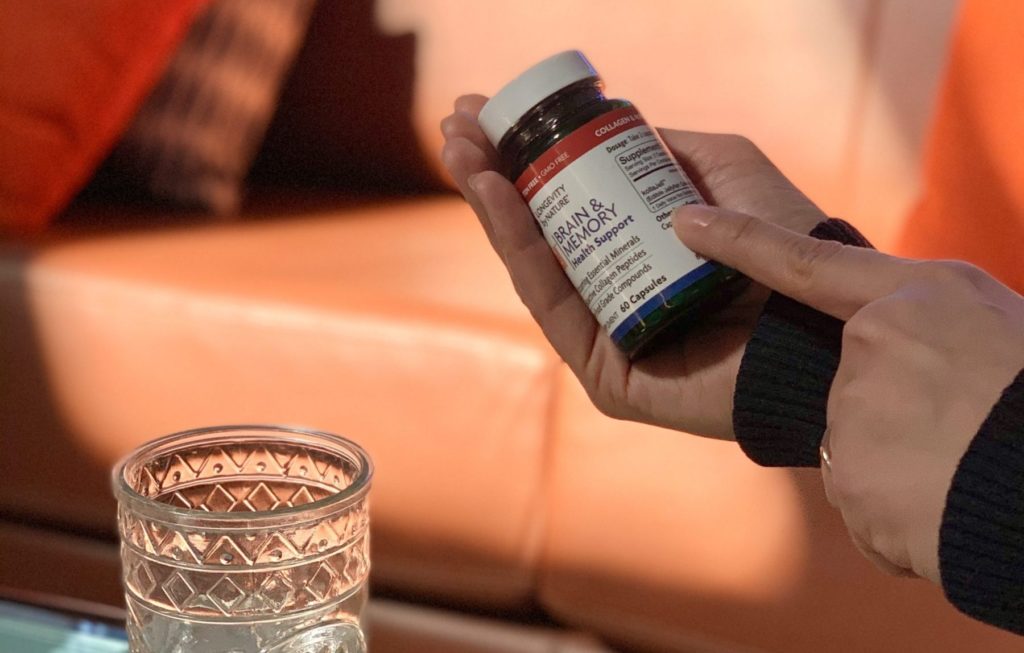 woman reading and pointing to supplement label